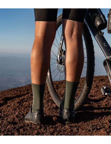 cyclist wearing khaki Luxa cycling socks and stands on volcanic dust. Designed to adventure gravel rides.