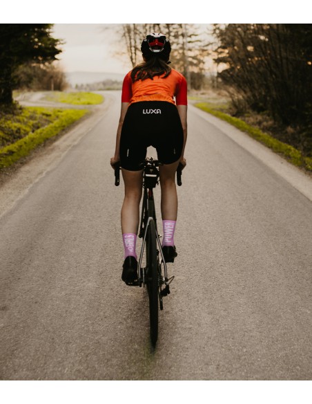 kobieta ubrana w damski strój rowerowy Luxa i liliowe skarpety z napisami "girls power"
