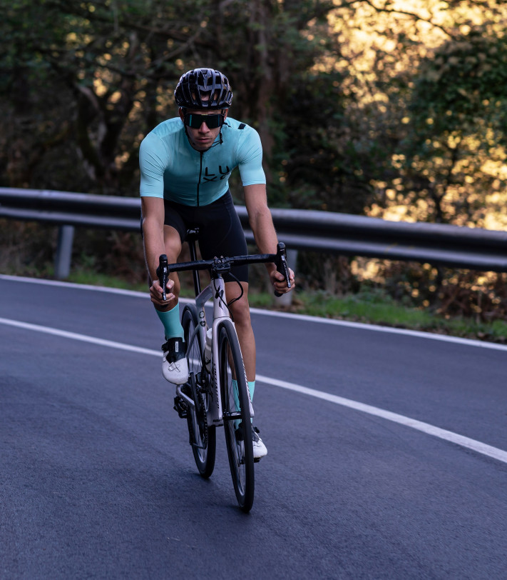 mężczyzna ubrany w miętowy strój kolarski i miętowe skarpetki rowerowe