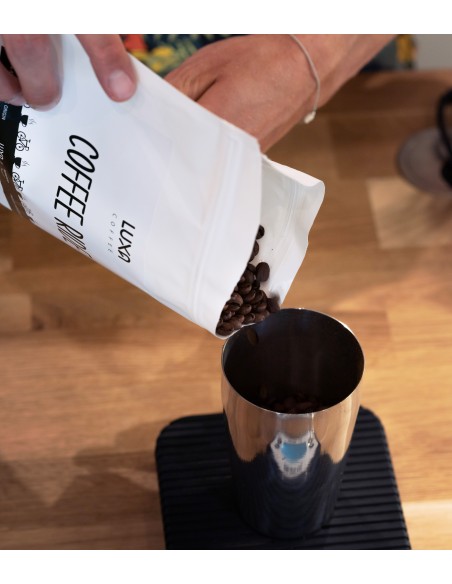 świeża kawa dla kolarza i rowerzysty przesypywana w celu zważenia ziaren