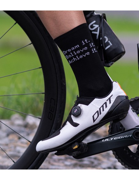 left leg of road cyclists who is wearing DMT shoes and Luxa socks with message on one side