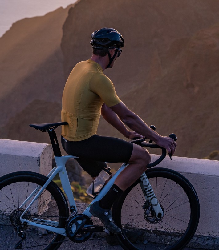 kolarz ubrany w polską odzież dla kolarzy Luxa i skarpetki aero z logo, całe czarne