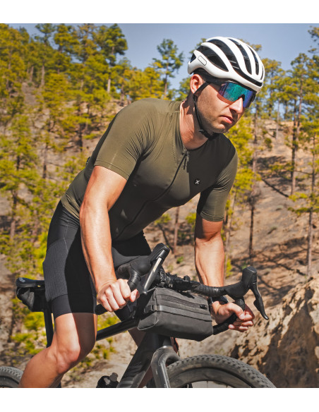 Cyclist wearing Supreme Evergreen jersey on a forest trail
