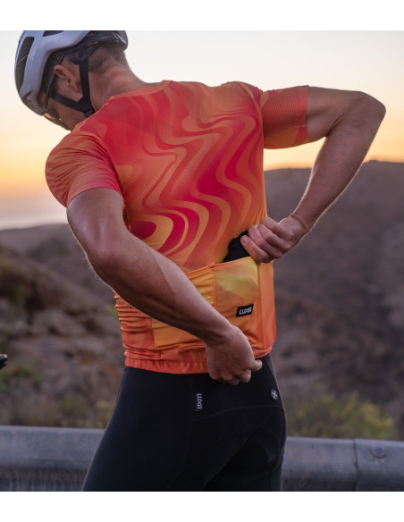 Luxa Core Ultralight Black jacket - cyclist packing the jacket into jersey pocket