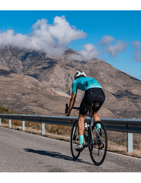 kolarz na szosie w miętowym stroju ze skarpetkami