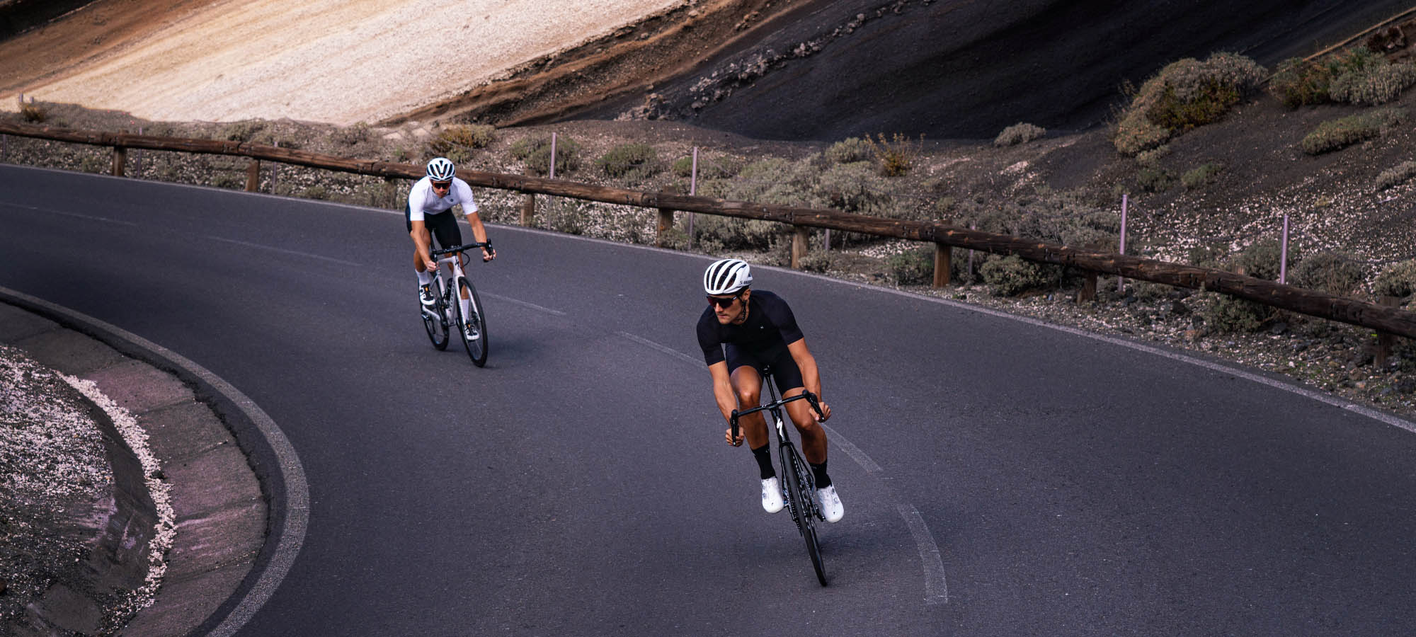 kolarze jadą w d&oacute;ł z przełęczy Nivolet we Włoszech w czarnych koszulkach rowerowych Luxa Supreme