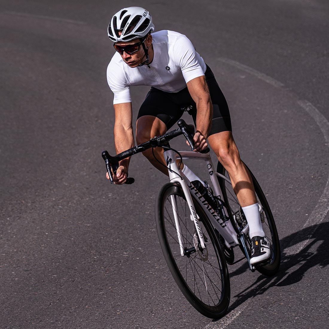 ubrany w biały str&oacute;j rowerowy kolarz nosi profesjonalną odzież dla kolarzy Luxa