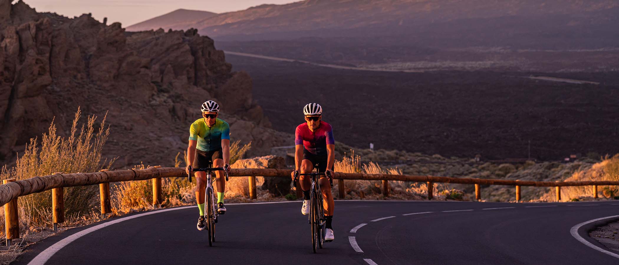 zachodzące słońce pod Teide na Teneryfie i kolarze jadący w strojach rowerowych polskiej marki Luxa