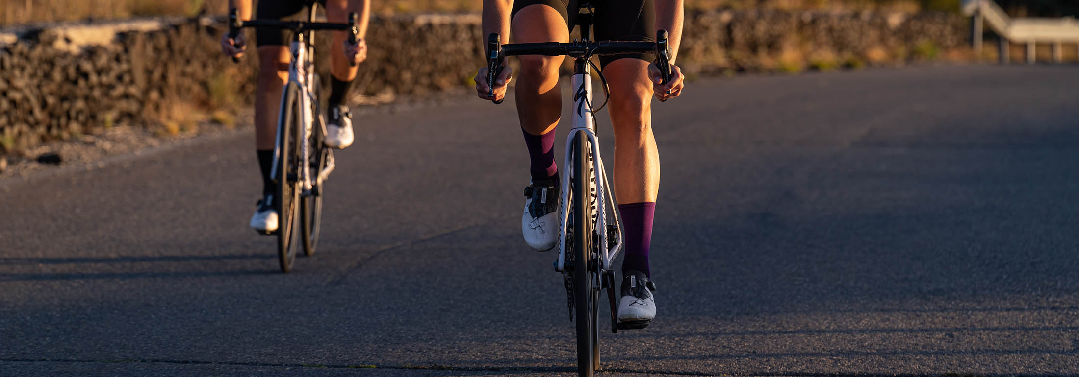 two cyclists during sunrise ride and one of them wear Luxa purple socks