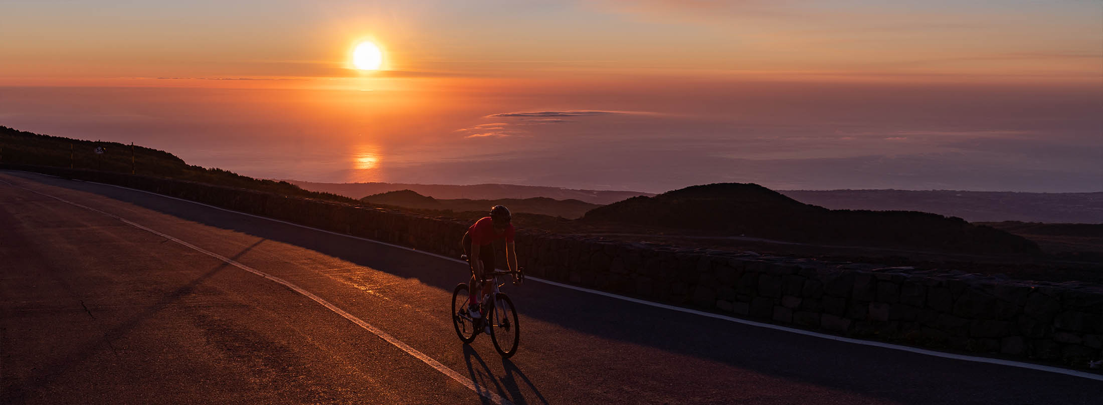 setting sun on Sicily (Etna) and Luxa cyclist on the road